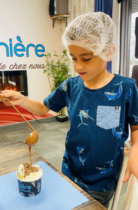 Atelier qui ajoute du chocolat à sa crème glacée dans un atelier éducatif de la Pralinière