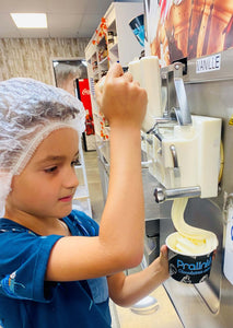 Enfant qui prépare sa crème glacée dans un atelier familial amusant