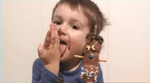 Charger l&#39;image dans la galerie, Enfant qui se liche les doigts après avoir participé à un atelier de chocolat