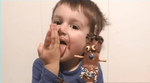Enfant qui se liche les doigts après avoir participé à un atelier de chocolat