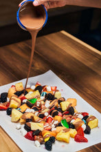 Charger l'image dans la galerie, Fondue au chocolat coulée sur des fruits au centre de la table